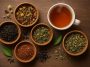 Assorted tea blends in cups and jars displayed on a wooden table for choosing the right tea